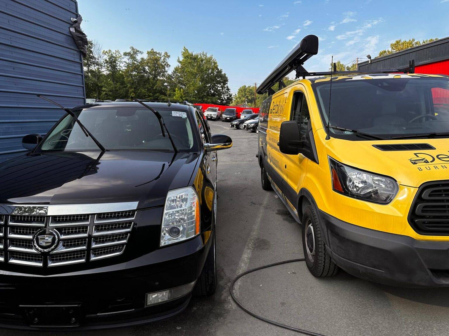 Car Detail 360 van beside a black Cadillac Escalade at a dealership lot