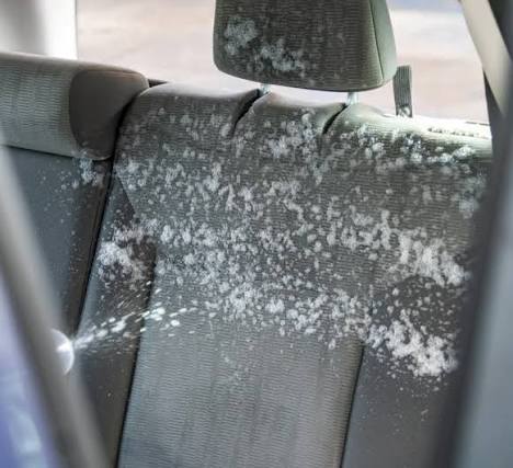 Cleaning foam sprayed across a fabric rear car seat