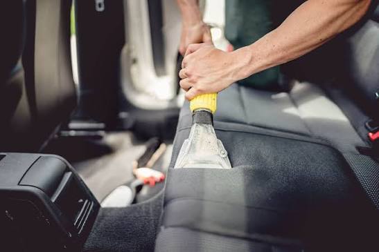 Extraction wand cleaning a grey fabric car seat